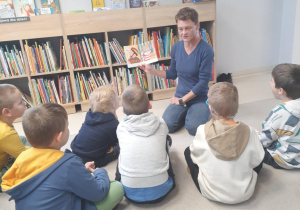 Wizyta Zajączków w Bibliotece Rozgrywka - dzieci słuchają czytanych bajek