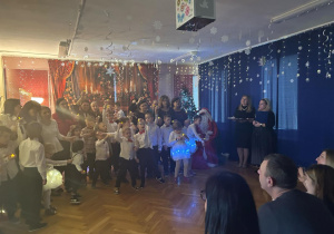 Dzieci z wszystkich grup stoją z nauczycielkami na scenie