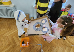 Bal Karnawałowy - dzieci celują piłką w otwór