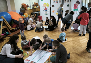 Dzieci przyklejają liście do kartonu
