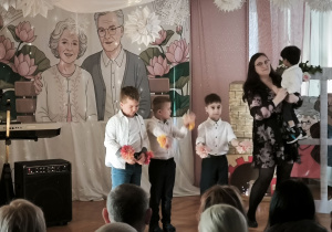 Dzieci z grupy Tygrysków występują mając przyczepione opaski z kwiatkami do rąk