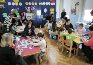 Dzieci z wszystkich przedszkoli rywalizują w grach. Wszyscy uczestnicy siedzą przy czterech stołach i grają ze sobą (po dwa przedszkola przy jednym stole)