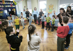 Dzieci z biorące udział w olimpiadzie stoją w kręgu i klaszczą w dłonie