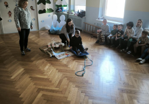 Chłopiec w okularach siedzi na plastikowych sankach