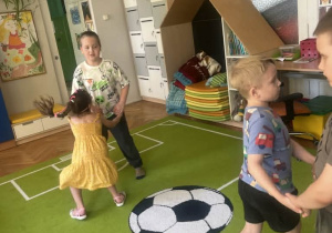 Dzieci trzymają się za ręce i tańczą