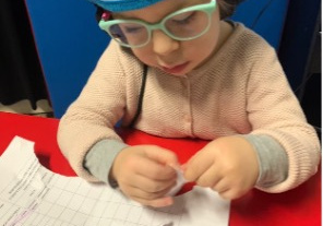 Zajęcia metodą Tomatisa - dziecko pracuje na kartkach papieru, ma słuchawki na uszach