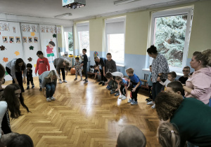 Dzieci stoją w kole, wykonują skłon w kierunku stóp