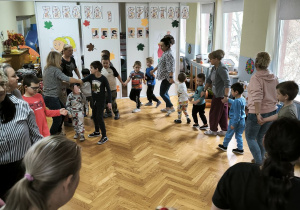 Dzieci tańczą w kole, trzymając się za ręce