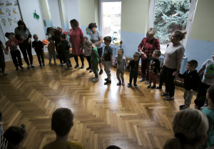 Dzieci stoją w kole i trzymają się za ręce