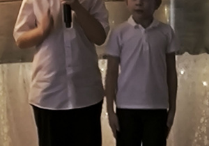 Kuba z grupy Zajączków występuje trzymając mikrofon, po prawej stronie chłopca stoi Gabryś z grupy Zajączków