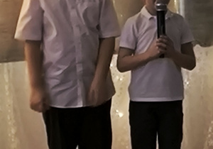 Gabryś z grupy Zajączków występuje trzymając mikrofon, po prawej stronie chłopca stoi Kuba z grupy Zajączków