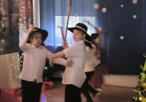Dzieci z grupy Zajączków tańczą trzymając ciupagi
