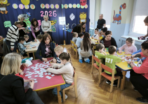 Dzieci z wszystkich przedszkoli rywalizują w grach. Wszyscy uczestnicy siedzą przy czterech stołach i grają ze sobą (po dwa przedszkola przy jednym stole)