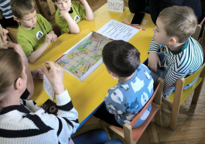 Dzieci z Przedszkola Miejskiego 206 oraz Przedszkola Miejskiego 221 rywalizują w grach planszowych siedząc przy stoliku wraz z opiekunkami