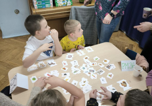 Dzieci z Przedszkola Miejskiego 36 oraz Przedszkola Miejskiego Specjalnego nr 1 rywalizują w grach planszowych siedząc przy stoliku wraz z opiekunkami