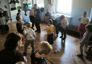 Dzieci rzucają do siebie papierowymi śnieżkami