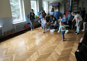 Dwie dziewczynki niosą w kubkach piłeczki