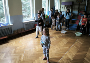 Chłopiec i dziewczynka niosą w kubkach piłeczki