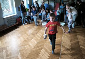 Dwóch chłopców niesie w kubkach piłeczki