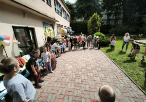 Dzieci w kole trzymają się za kolana