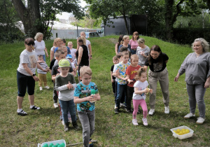 Dzieci trzymają kulki, jedna grupa zielone, druga żółte