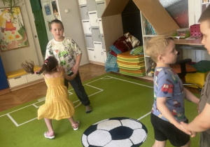 Dzieci trzymają się za ręce i tańczą