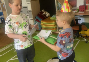 Kolega wręcza Kubie kartkę